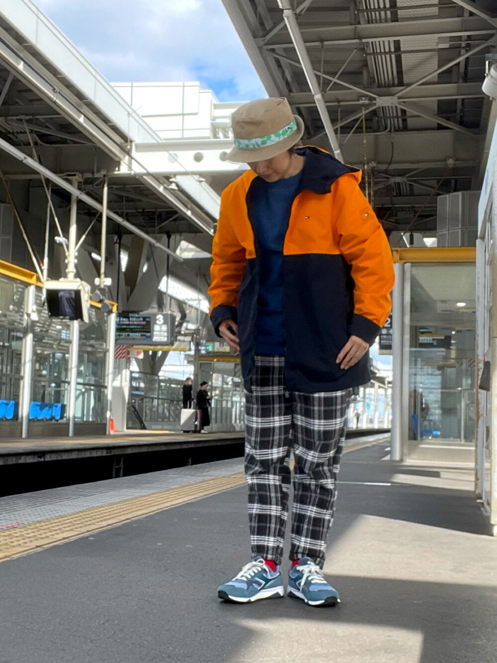 ブラック系のその他パンツ、ブルー系のスウェット、オレンジ系のマウンテンパーカーを着用したレディースの秋コーディネートの2枚目の写真
