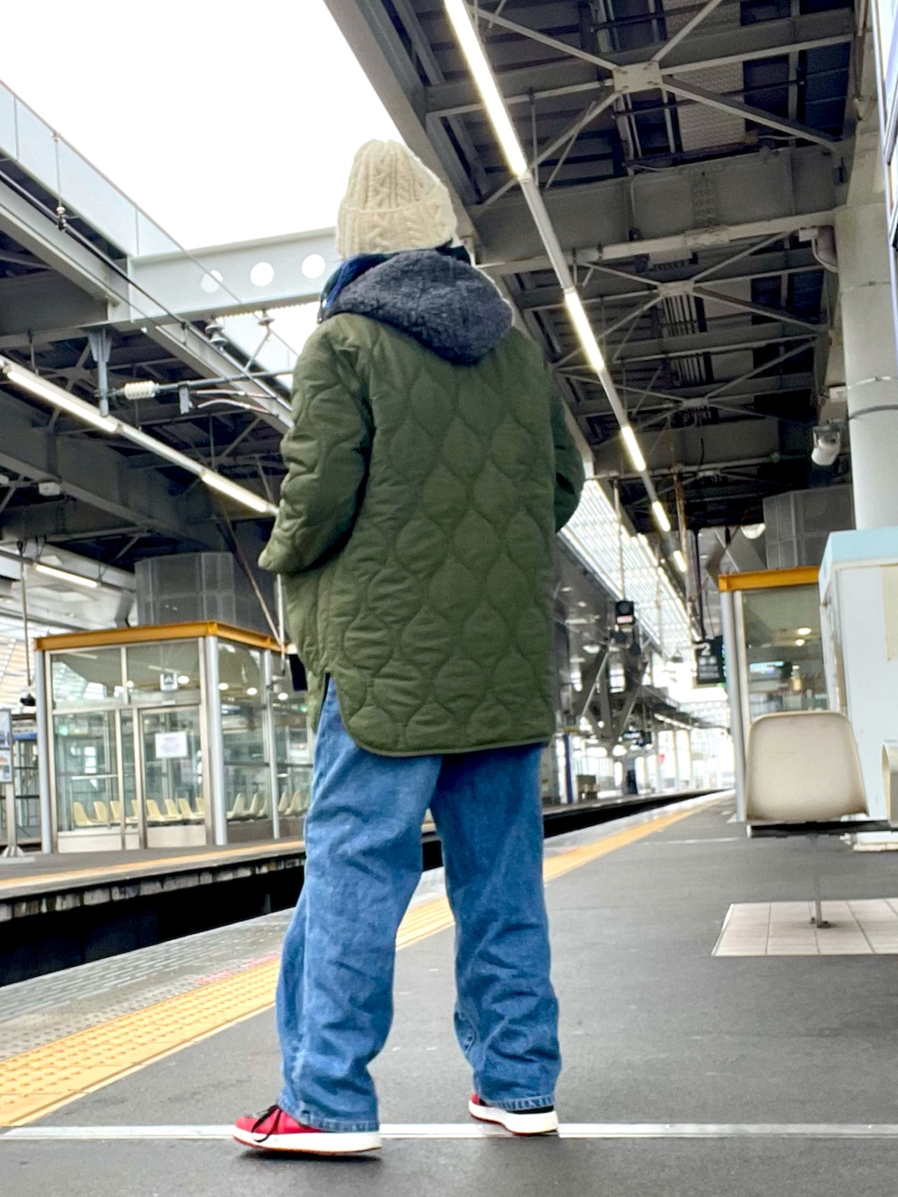 ブルー系のデニムパンツ、グレー系のベスト、グリーン系のジャケット/アウターを着用したレディースの春コーディネートの2枚目の写真