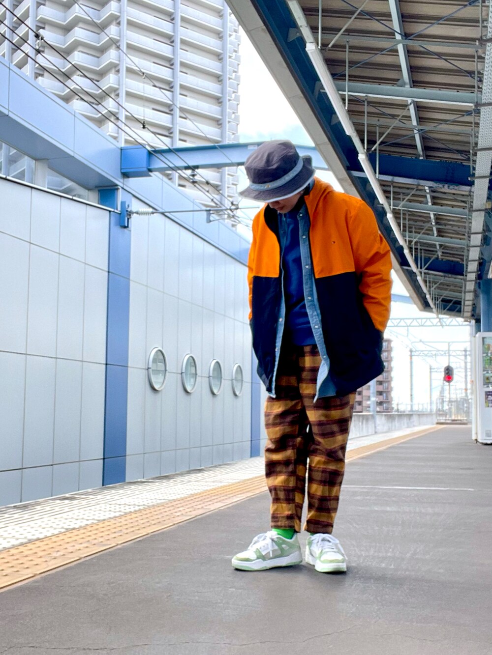 オレンジ系のマウンテンパーカー、ブラウン系のその他パンツ、ブルー系のスウェットを着用したレディースの春コーディネートの3枚目の写真