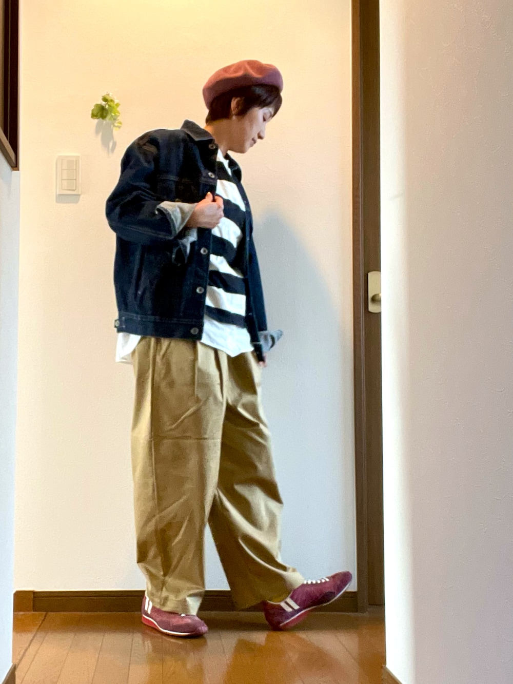 ブラック系のTシャツ/カットソー、レッド系のスニーカー、ブルー系のデニムジャケットを着用したレディースの秋コーディネートの2枚目の写真
