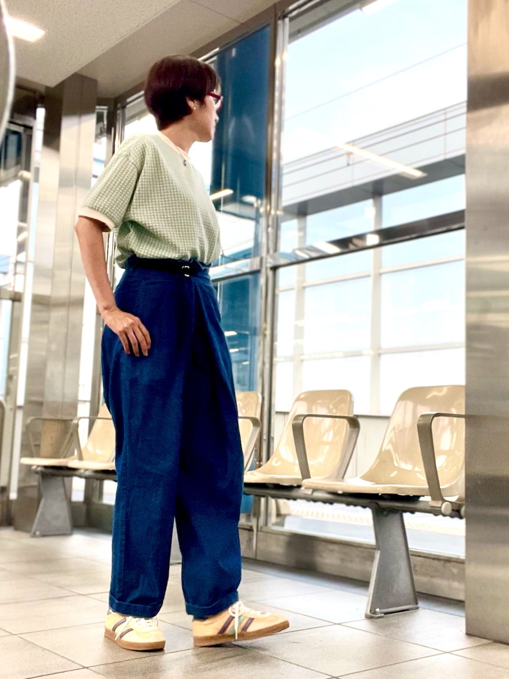 オレンジ系のスニーカー、グリーン系のTシャツ/カットソー、ブルー系のデニムパンツを着用したレディースの夏コーディネートの2枚目の写真