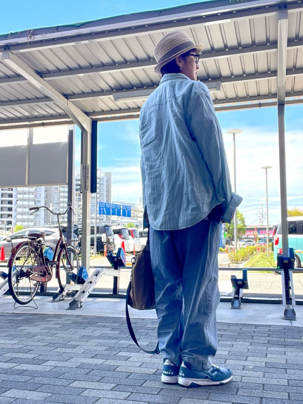 ベージュ系のショルダーバッグ、ブルー系のデニムパンツ、ブルー系のシャツ/ブラウスを着用したレディースの秋コーディネートの3枚目の写真