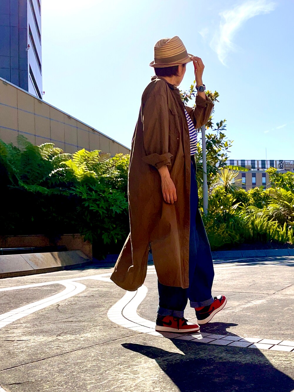 ブルー系のデニムパンツ、ブルー系のTシャツ/カットソー、レッド系のスニーカーを着用したレディースの春コーディネートの3枚目の写真