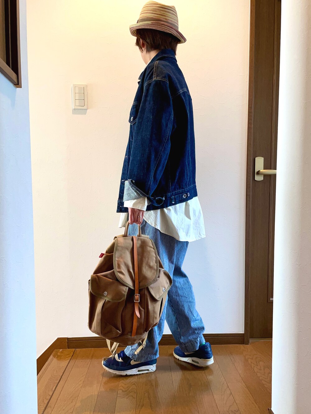 ブルー系のデニムジャケット、ブルー系のデニムパンツ、ベージュ系のバックパック/リュックを着用したレディースの春コーディネートの3枚目の写真