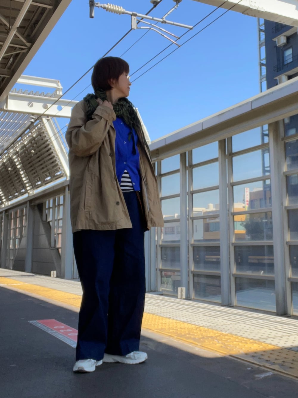 ホワイト系のTシャツ/カットソー、ベージュ系のジャケット/アウター、ブルー系のデニムパンツを着用したレディースの春コーディネートの2枚目の写真