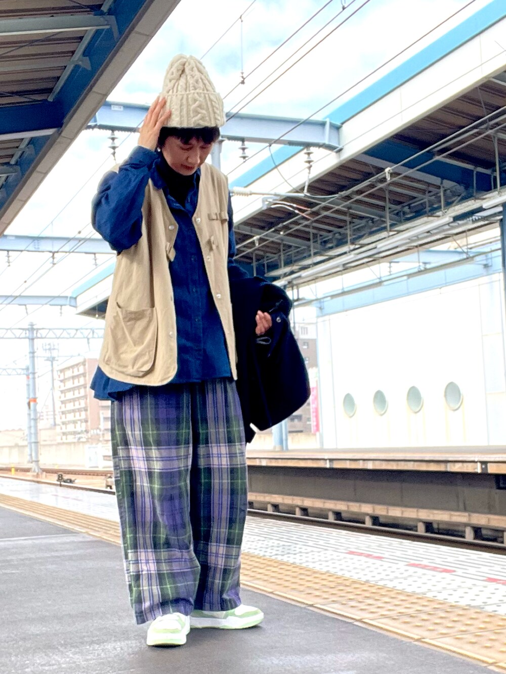 ブルー系のその他パンツ、ベージュ系のベスト、グリーン系のスニーカーを着用したレディースの春コーディネートの3枚目の写真