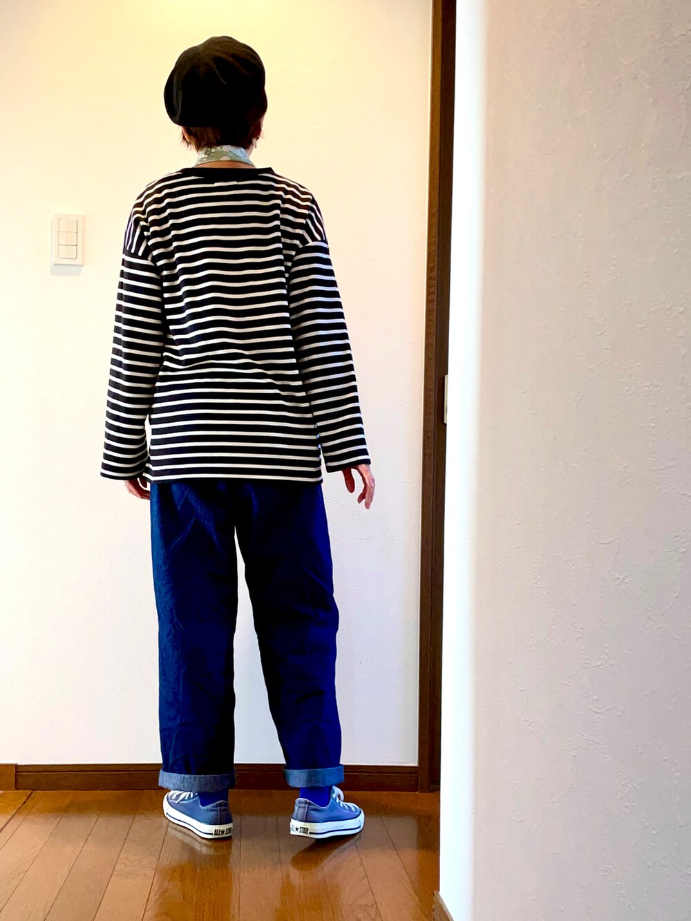 ブルー系のデニムパンツ、ブラック系のTシャツ/カットソー、ブルー系のスニーカーを着用したレディースの秋コーディネートの4枚目の写真