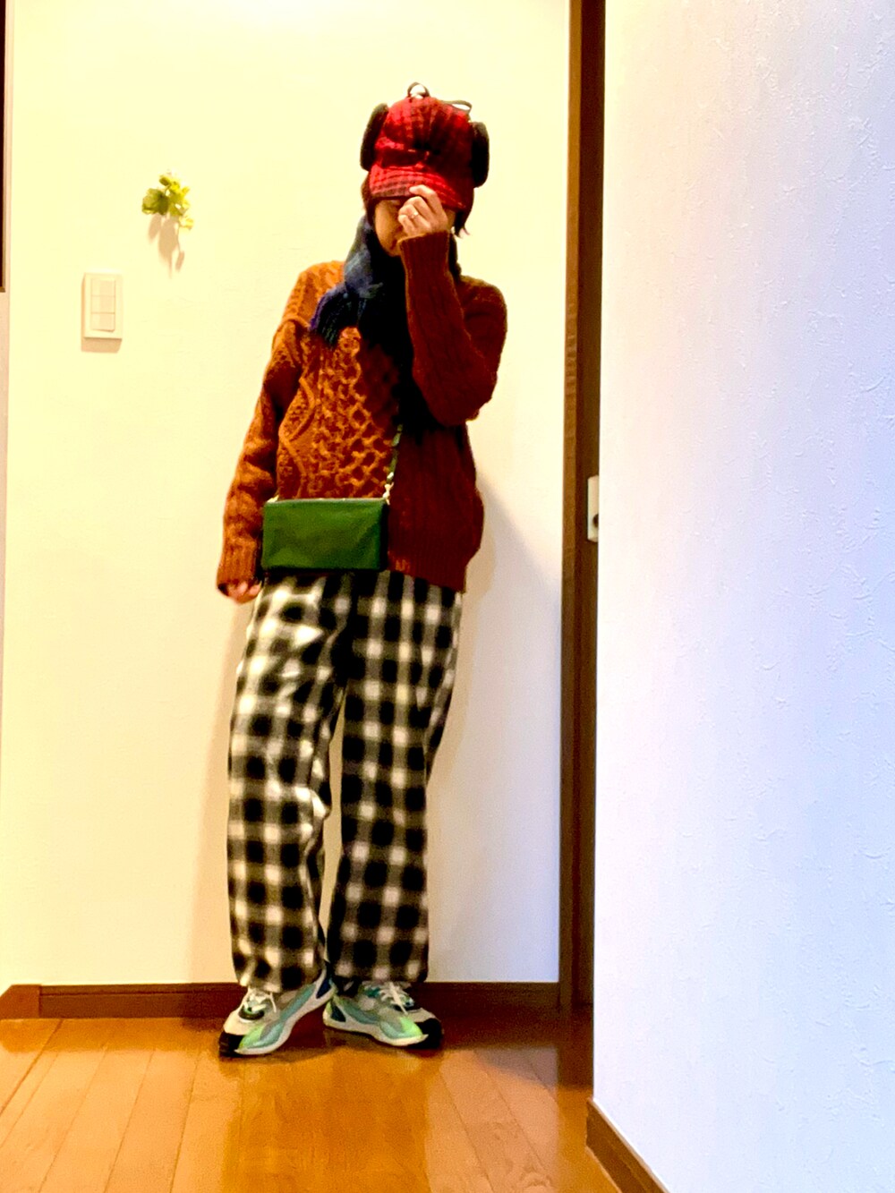 ブラウン系のニット/セーター、グリーン系のその他パンツ、ブラック系のスニーカーを着用したレディースの冬コーディネートの3枚目の写真