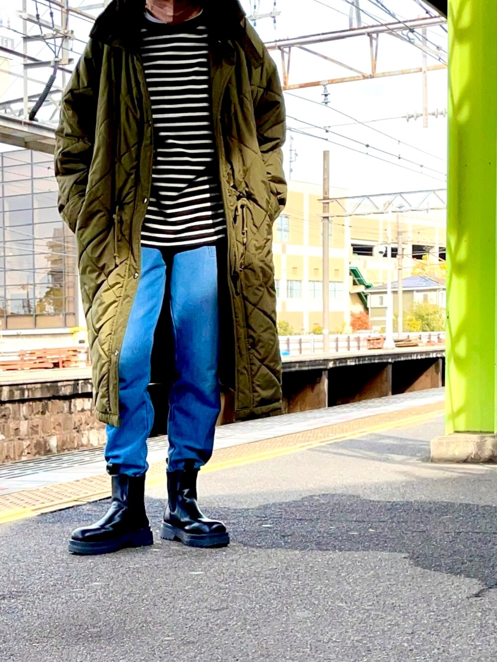 グリーン系のその他アウター、ブラック系のTシャツ/カットソー、ブルー系のスウェットパンツを着用したレディースの冬コーディネートの4枚目の写真