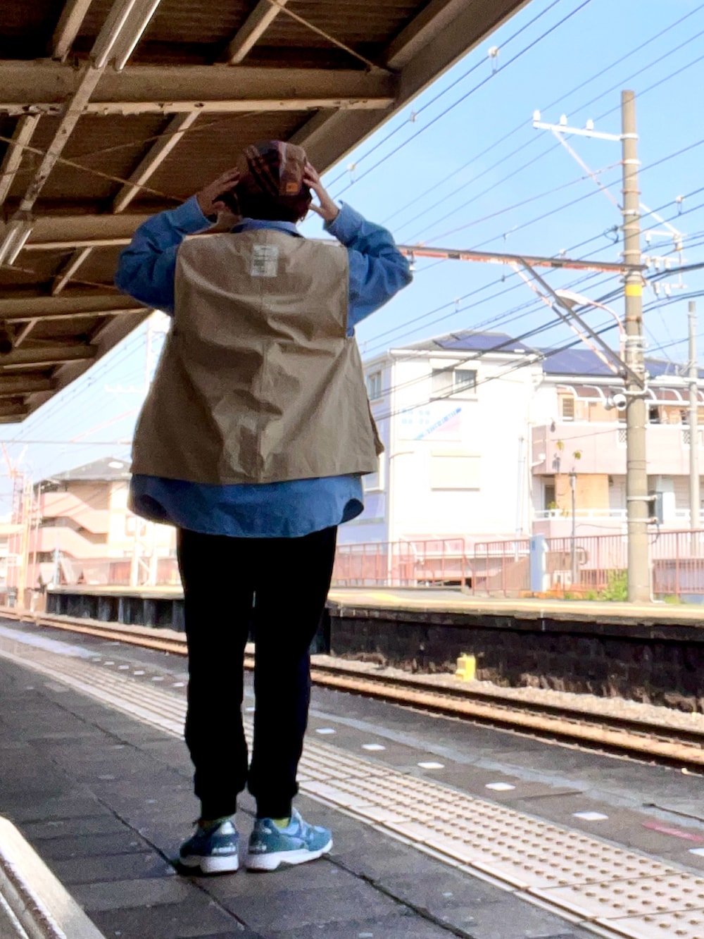 ブルー系のTシャツ/カットソー、ベージュ系のベスト、ブルー系のシャツ/ブラウスを着用したレディースの春コーディネートの2枚目の写真