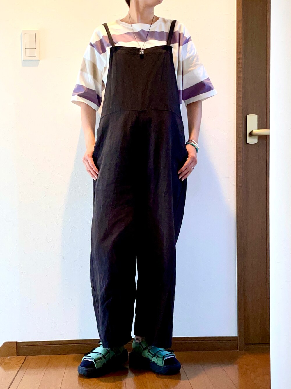 パープル系のTシャツ/カットソー、ブラック系のサロペット/オーバーオール、グリーン系のサンダルを着用したレディースの夏コーディネートの4枚目の写真