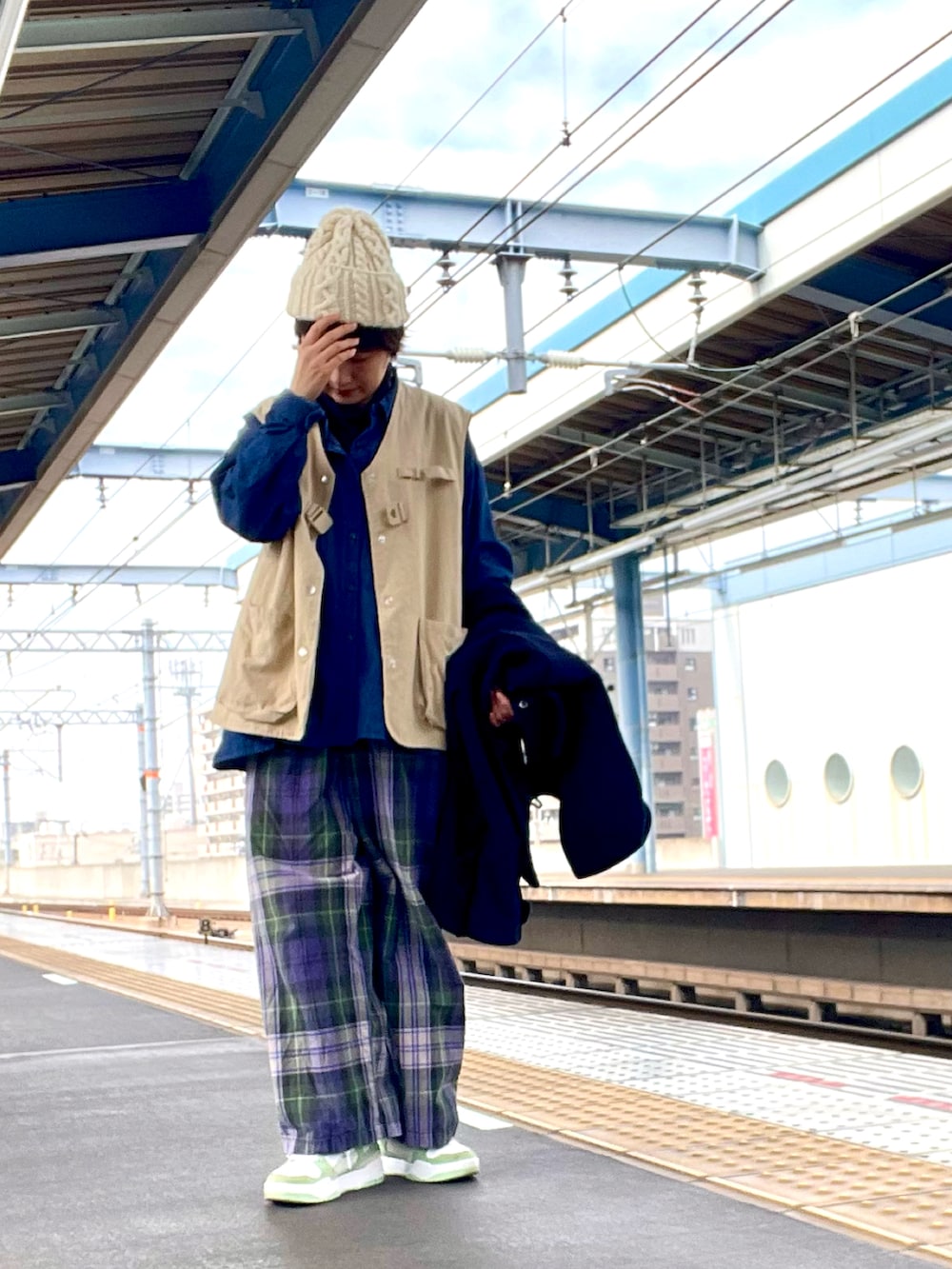 ブルー系のその他パンツ、ベージュ系のベスト、グリーン系のスニーカーを着用したレディースの春コーディネートの2枚目の写真