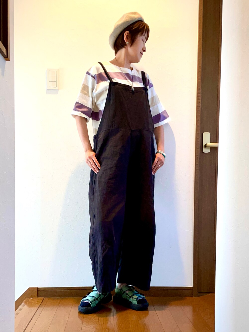 パープル系のTシャツ/カットソー、ブラック系のサロペット/オーバーオール、グリーン系のサンダルを着用したレディースの夏コーディネートの2枚目の写真