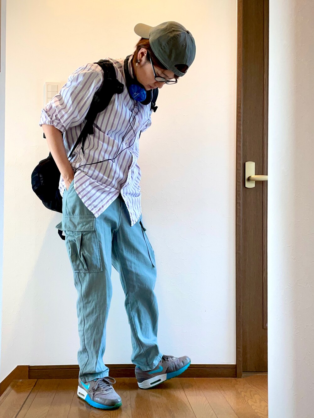 グリーン系のカーゴパンツ、ホワイト系のシャツ/ブラウス、グレー系のスニーカーを着用したレディースの夏コーディネートの3枚目の写真