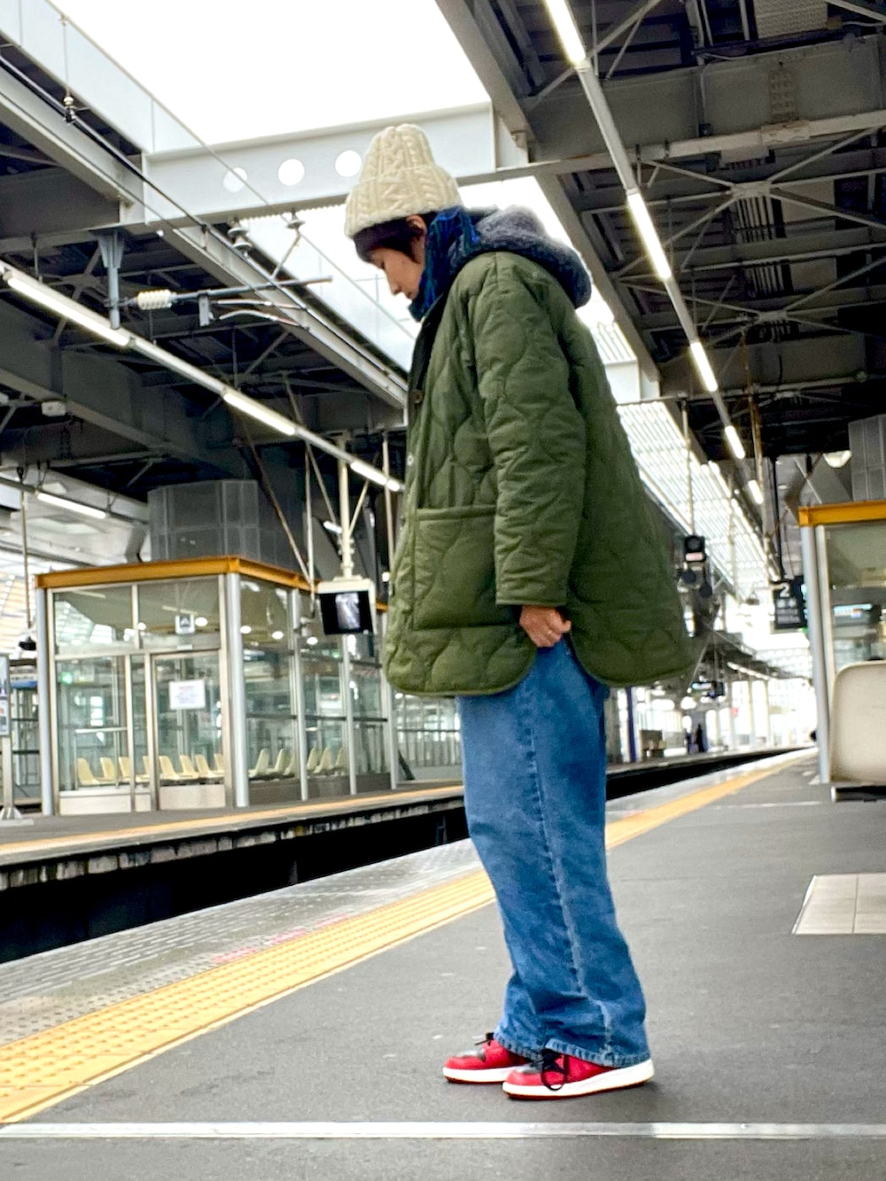 ブルー系のデニムパンツ、グレー系のベスト、グリーン系のジャケット/アウターを着用したレディースの春コーディネートの3枚目の写真