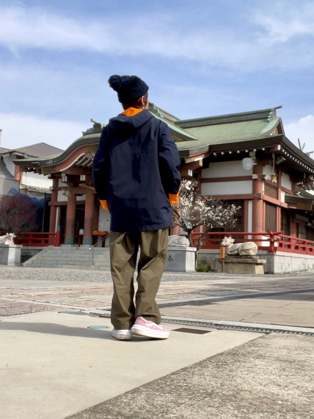 グリーン系のその他パンツ、オレンジ系のマウンテンパーカー、ピンク系のスニーカーを着用したレディースの春コーディネートの2枚目の写真