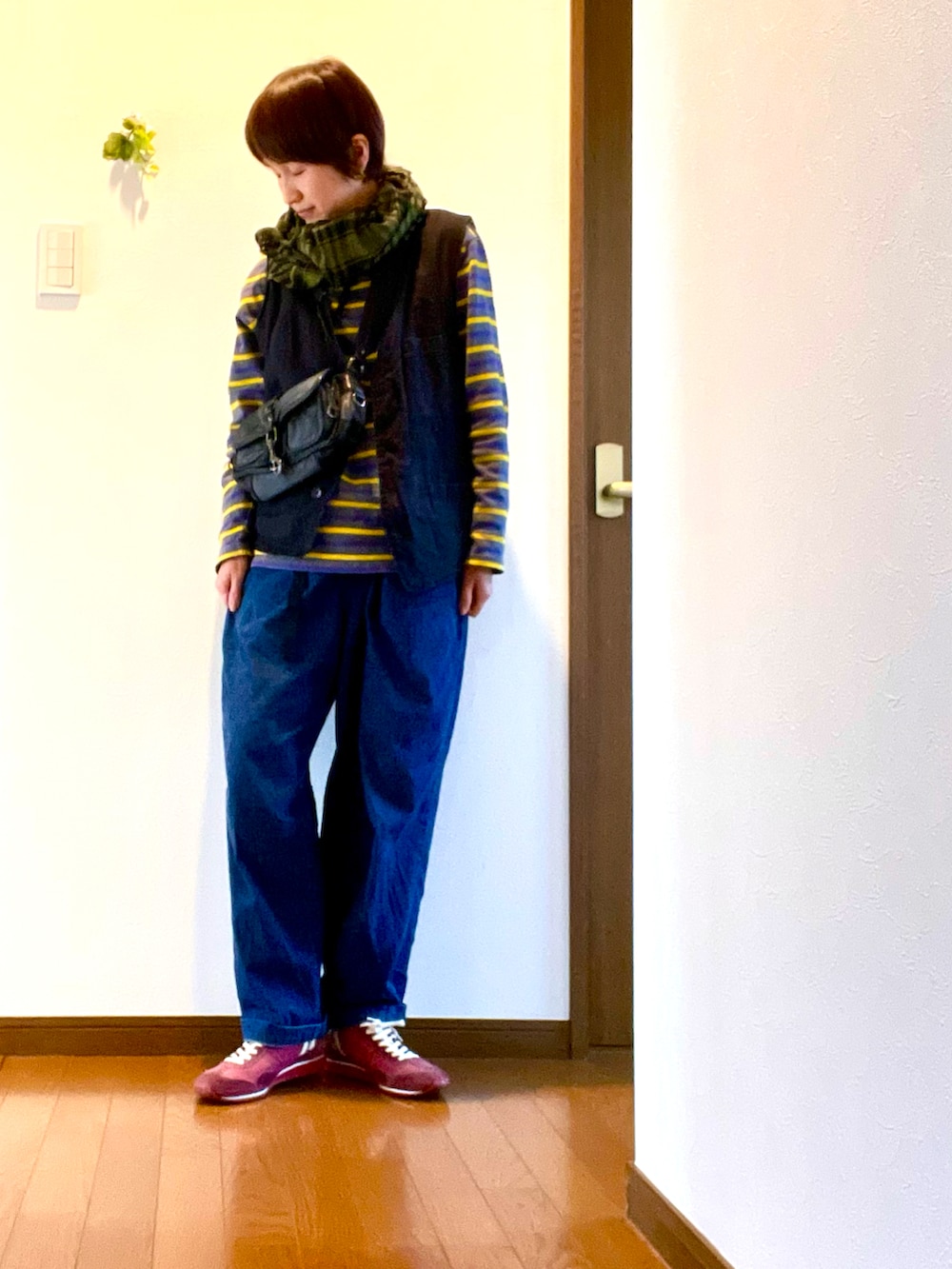 ブルー系のデニムパンツ、レッド系のスニーカー、グレー系のTシャツ/カットソーを着用したレディースの春コーディネートの2枚目の写真