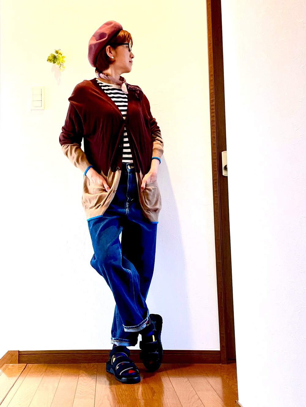 ブラウン系のカーディガン/ボレロ、ホワイト系のTシャツ/カットソー、ブルー系のデニムパンツを着用したレディースの夏コーディネートの2枚目の写真