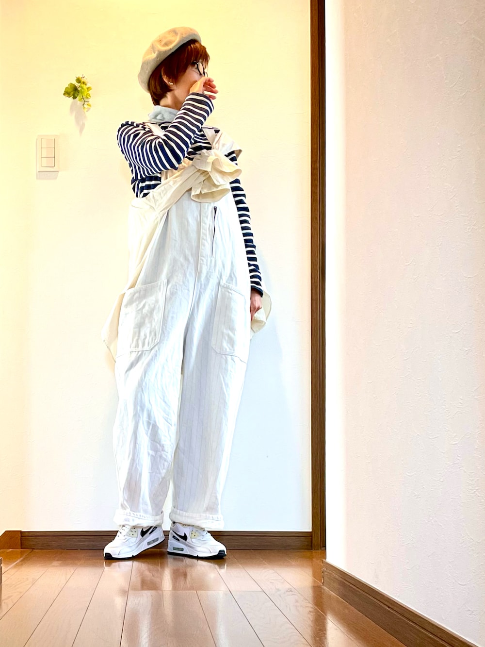 ホワイト系のサロペット/オーバーオール、ブルー系のTシャツ/カットソー、ホワイト系のスニーカーを着用したレディースの春コーディネートの3枚目の写真