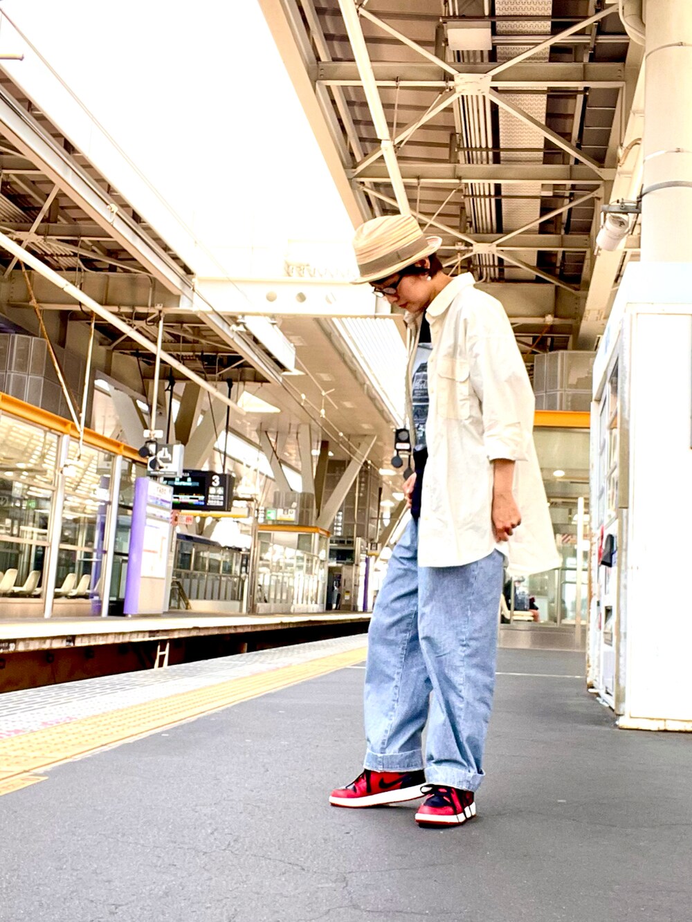 ブラック系のTシャツ/カットソー、ブルー系のデニムパンツ、レッド系のスニーカーを着用したレディースの夏コーディネートの3枚目の写真