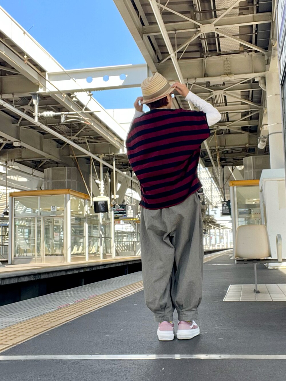 グレー系のその他パンツ、レッド系のTシャツ/カットソー、ピンク系のスニーカーを着用したレディースの秋コーディネートの3枚目の写真