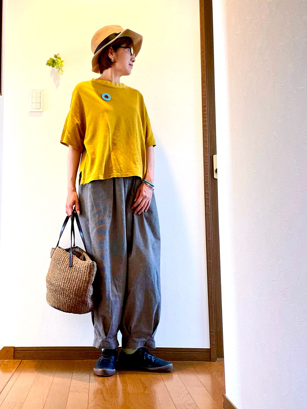 イエロー系のTシャツ/カットソー、グレー系のその他パンツ、ブラック系のドレスシューズを着用したレディースの夏コーディネートの3枚目の写真