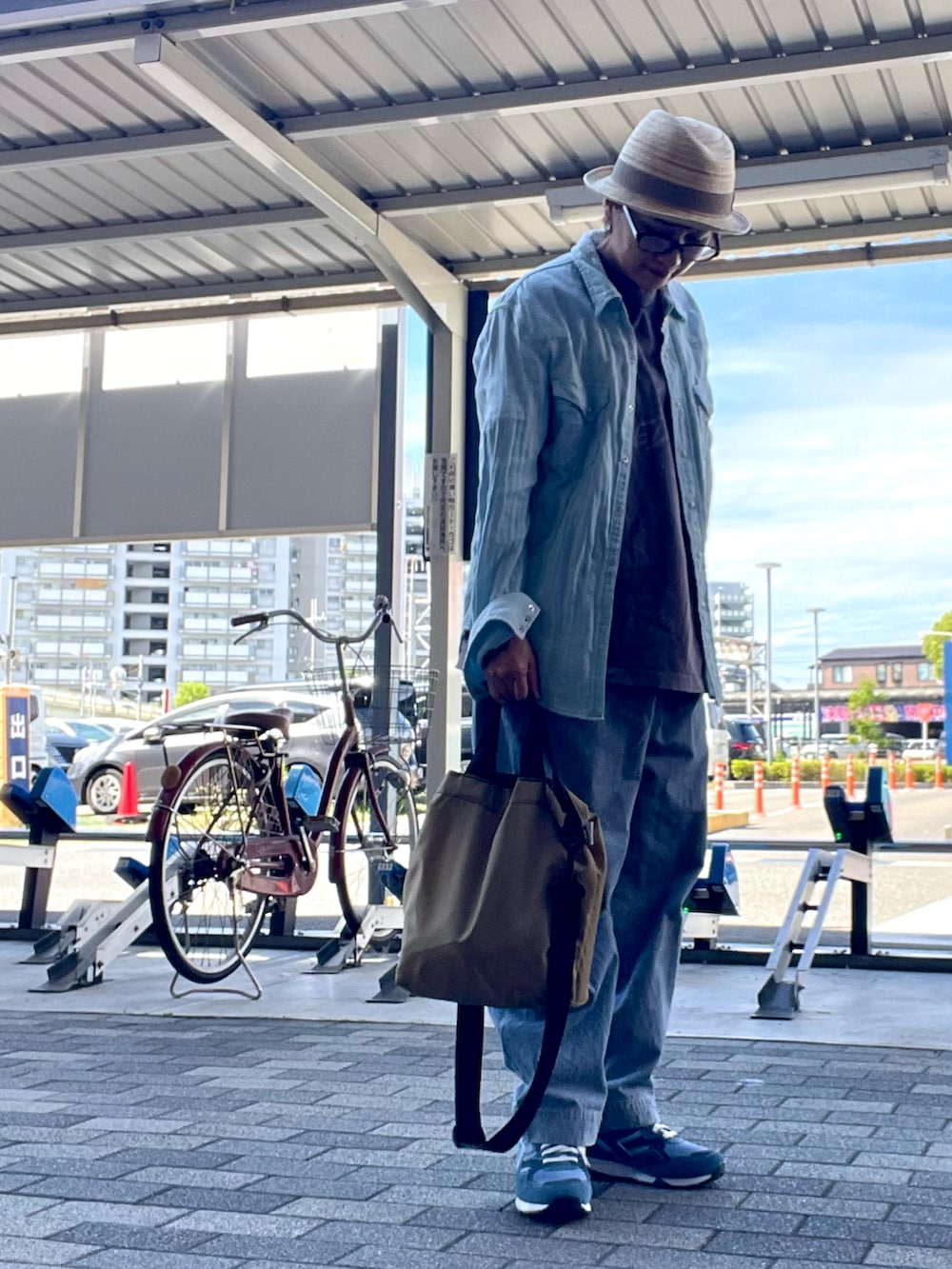 ベージュ系のショルダーバッグ、ブルー系のデニムパンツ、ブルー系のシャツ/ブラウスを着用したレディースの秋コーディネートの2枚目の写真