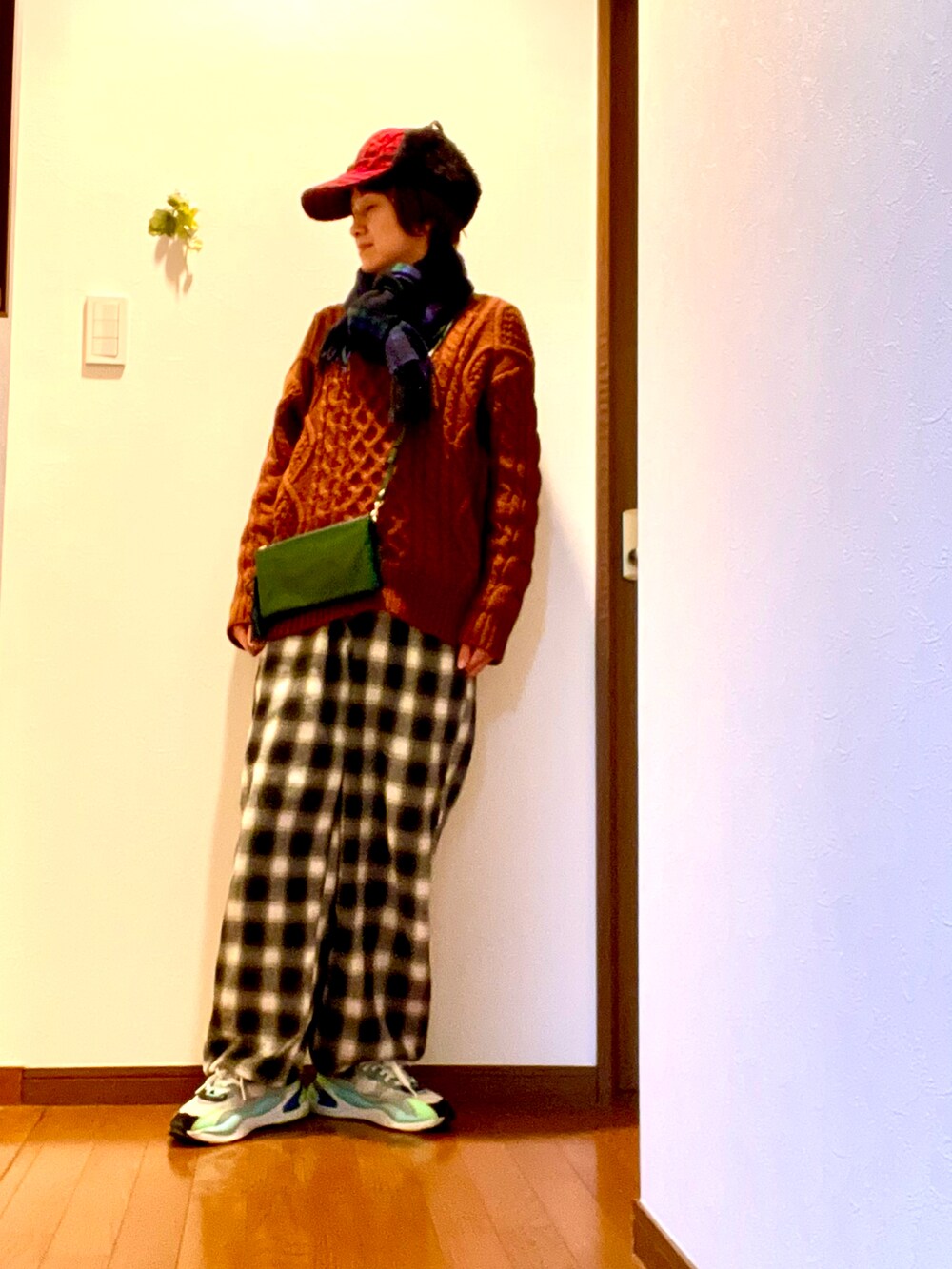 ブラウン系のニット/セーター、グリーン系のその他パンツ、ブラック系のスニーカーを着用したレディースの冬コーディネートの2枚目の写真