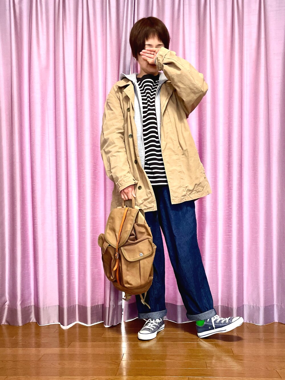 ベージュ系のジャケット/アウター、グレー系のパーカー、ブルー系のデニムパンツを着用したレディースの春コーディネートの2枚目の写真