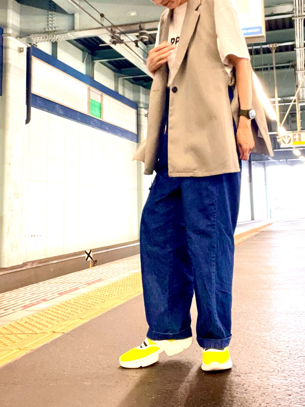 ブルー系のデニムパンツ、ホワイト系のTシャツ/カットソー、グリーン系のスニーカーを着用したレディースの夏コーディネートの2枚目の写真