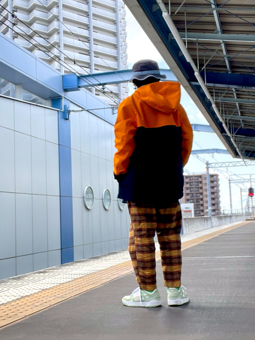オレンジ系のマウンテンパーカー、ブラウン系のその他パンツ、ブルー系のスウェットを着用したレディースの春コーディネートの2枚目の写真