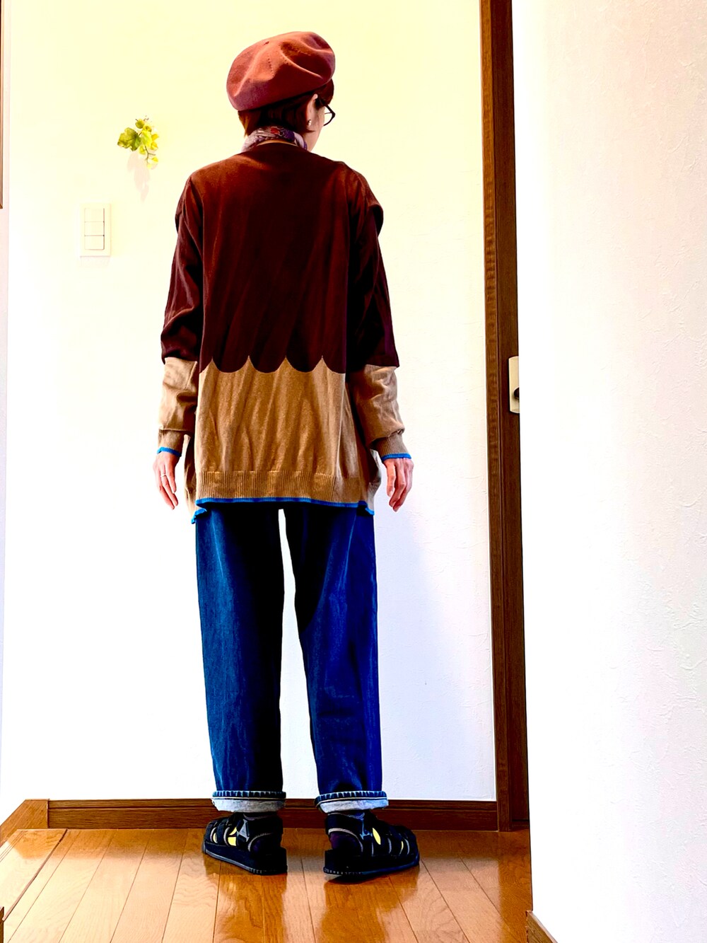 ブラウン系のカーディガン/ボレロ、ホワイト系のTシャツ/カットソー、ブルー系のデニムパンツを着用したレディースの夏コーディネートの4枚目の写真