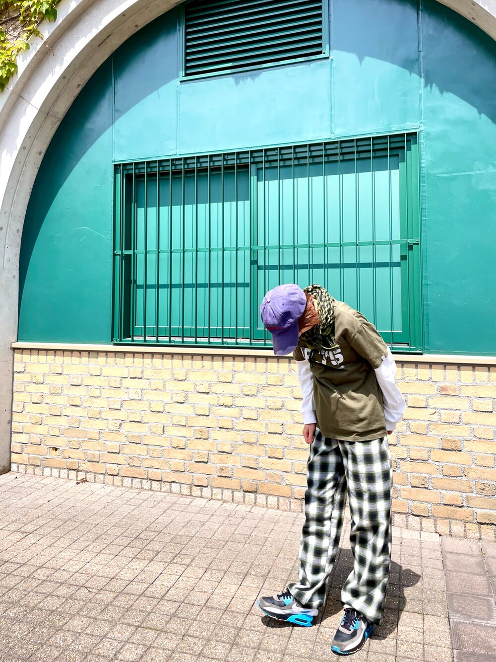 グリーン系のTシャツ/カットソー、グリーン系のその他パンツ、ブラック系のスニーカーを着用したレディースの春コーディネートの2枚目の写真