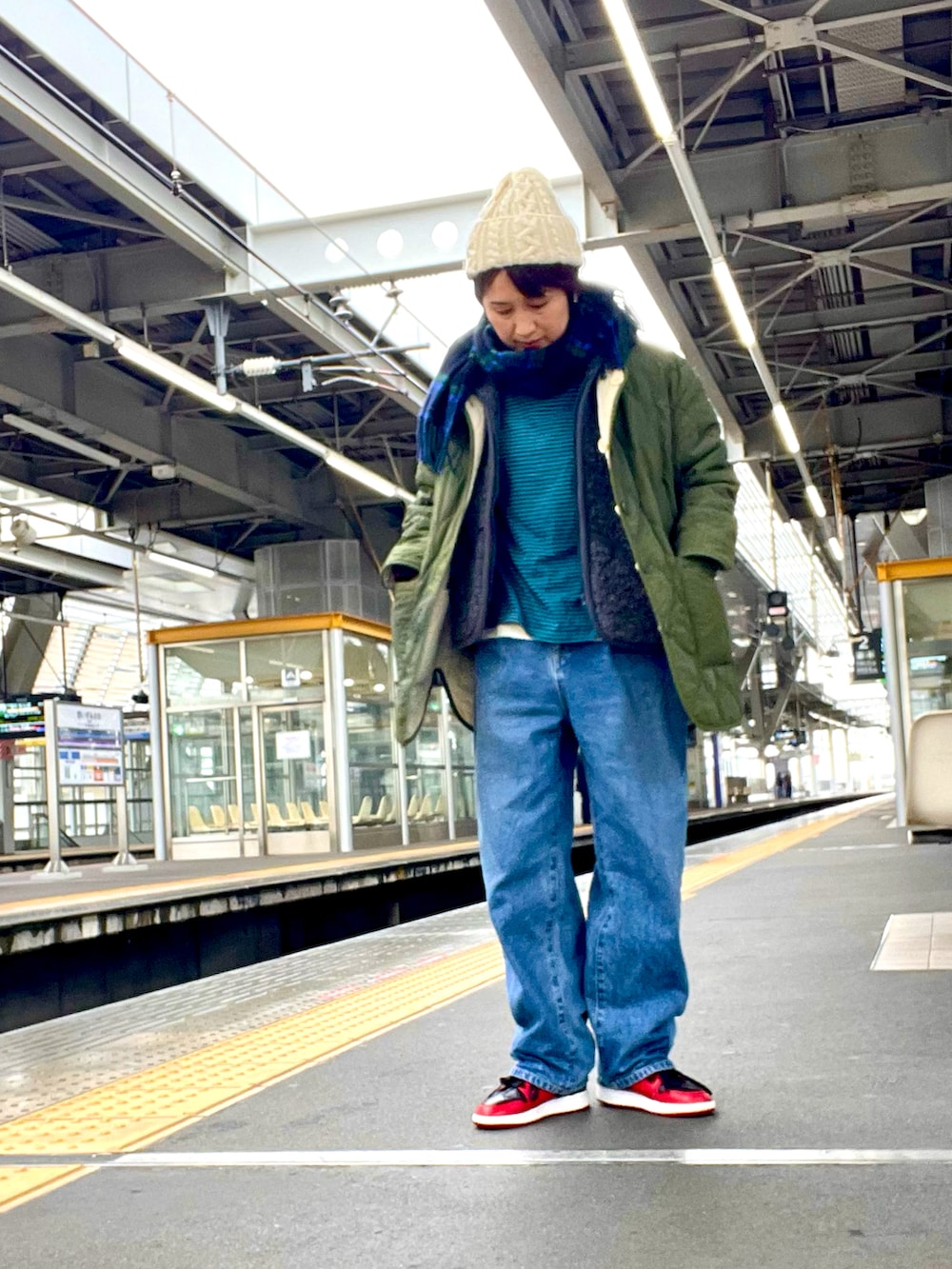 ブルー系のデニムパンツ、グレー系のベスト、グリーン系のジャケット/アウターを着用したレディースの春コーディネートの4枚目の写真