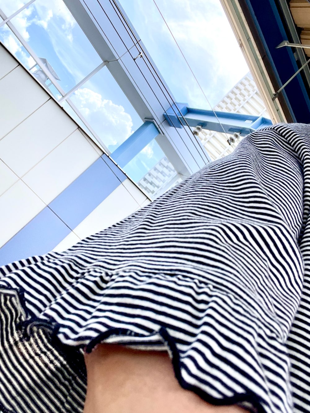 ホワイト系のTシャツ/カットソー、ベージュ系のチノパンツ、グリーン系のスニーカーを着用したレディースの夏コーディネートの4枚目の写真