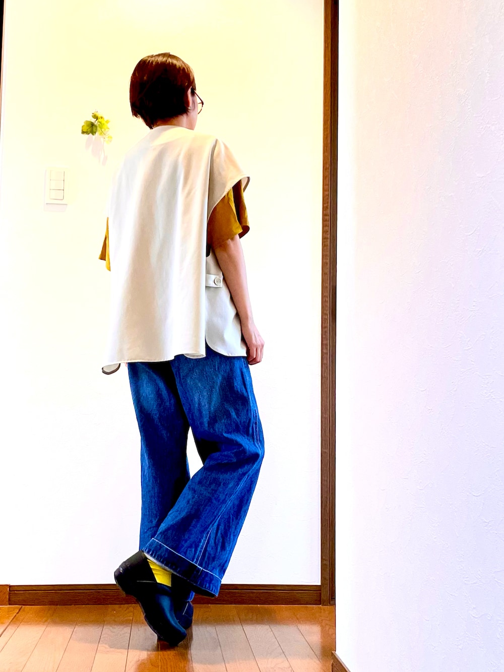 イエロー系のTシャツ/カットソー、ホワイト系のベスト、ブラック系のスリッポンを着用したレディースの夏コーディネートの3枚目の写真