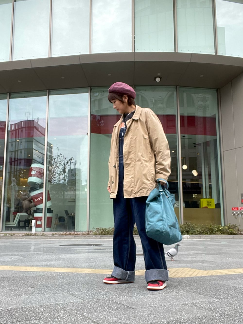 ブラック系のスウェット、ベージュ系のジャケット/アウター、ブルー系のサロペット/オーバーオールを着用したレディースの秋コーディネートの2枚目の写真