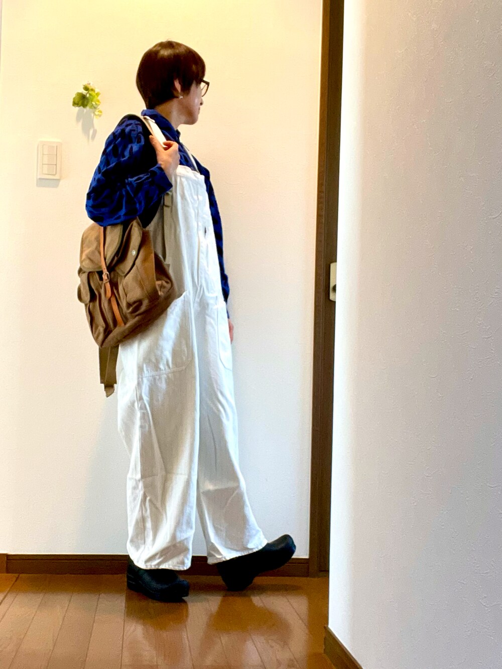 ブルー系のシャツ/ブラウス、ホワイト系のサロペット/オーバーオール、ブラック系のスリッポンを着用したレディースの春コーディネートの4枚目の写真