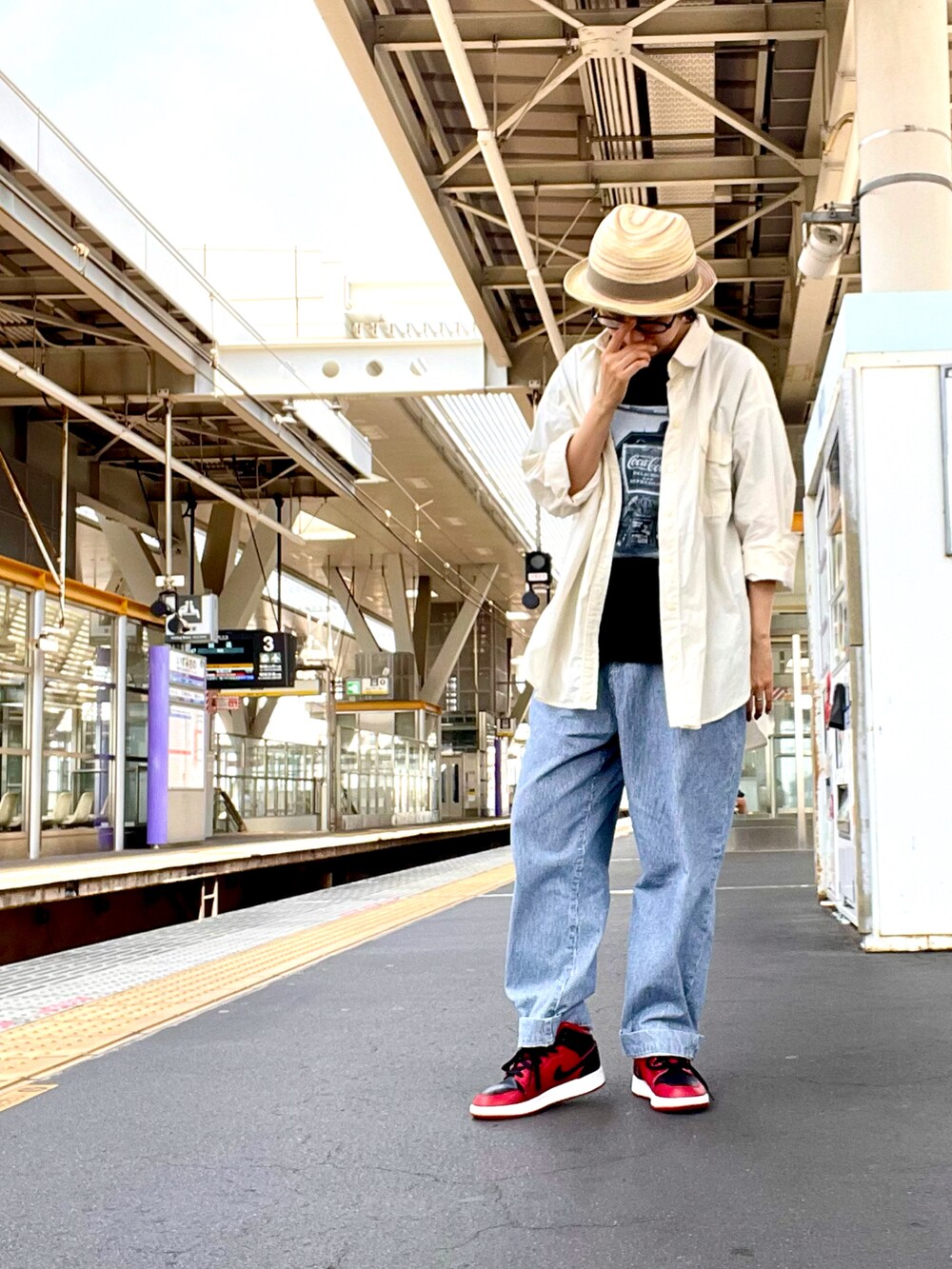 ブラック系のTシャツ/カットソー、ブルー系のデニムパンツ、レッド系のスニーカーを着用したレディースの夏コーディネートの2枚目の写真