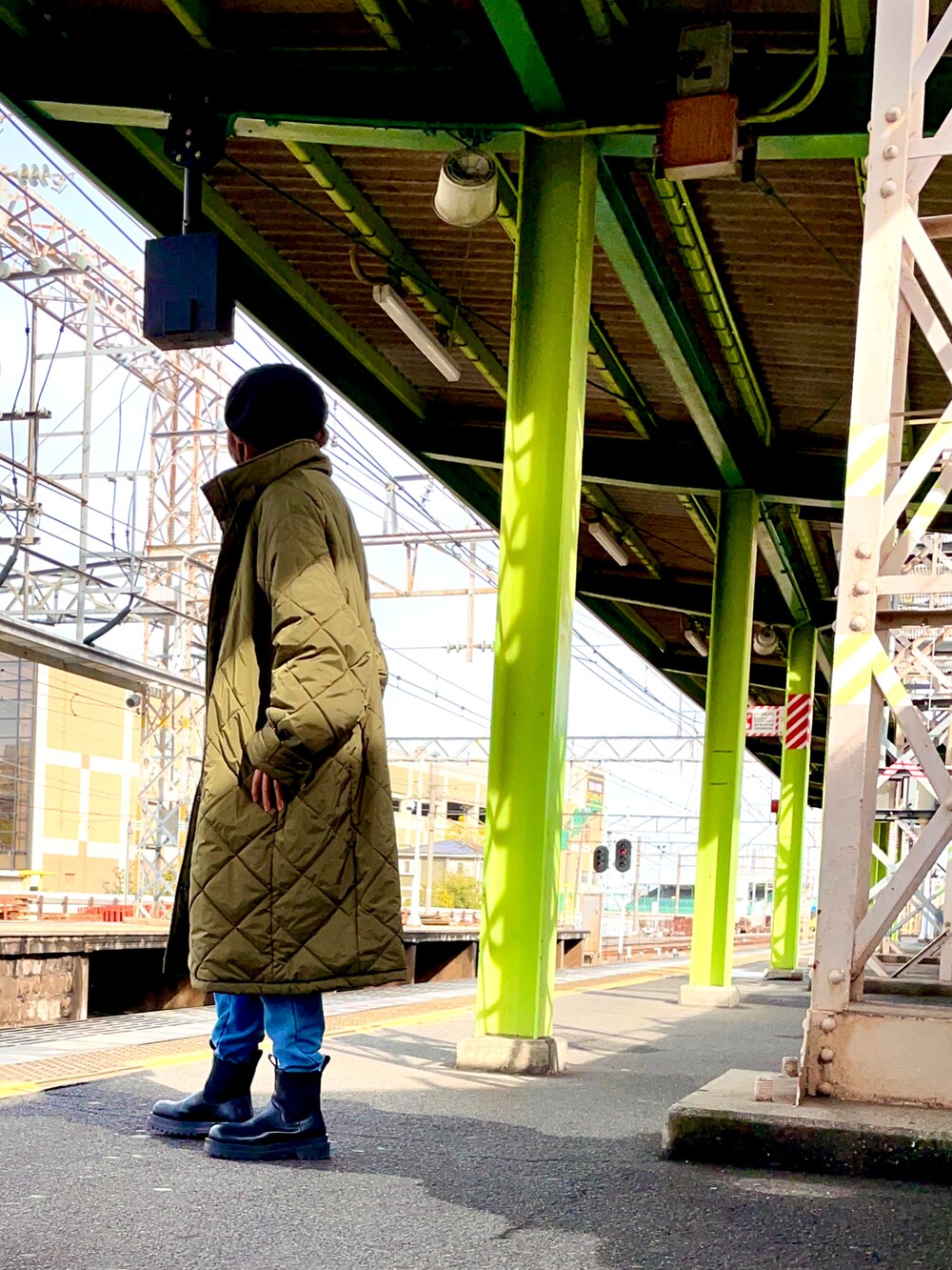 グリーン系のその他アウター、ブラック系のTシャツ/カットソー、ブルー系のスウェットパンツを着用したレディースの冬コーディネートの2枚目の写真