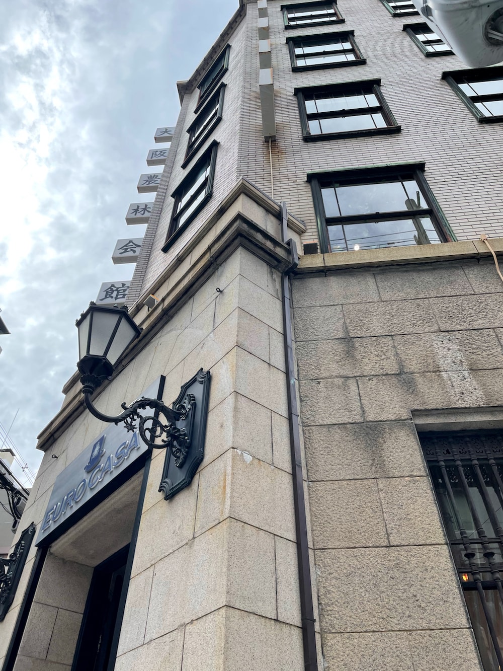 ブラック系のスウェット、ベージュ系のジャケット/アウター、ブルー系のサロペット/オーバーオールを着用したレディースの秋コーディネートの4枚目の写真