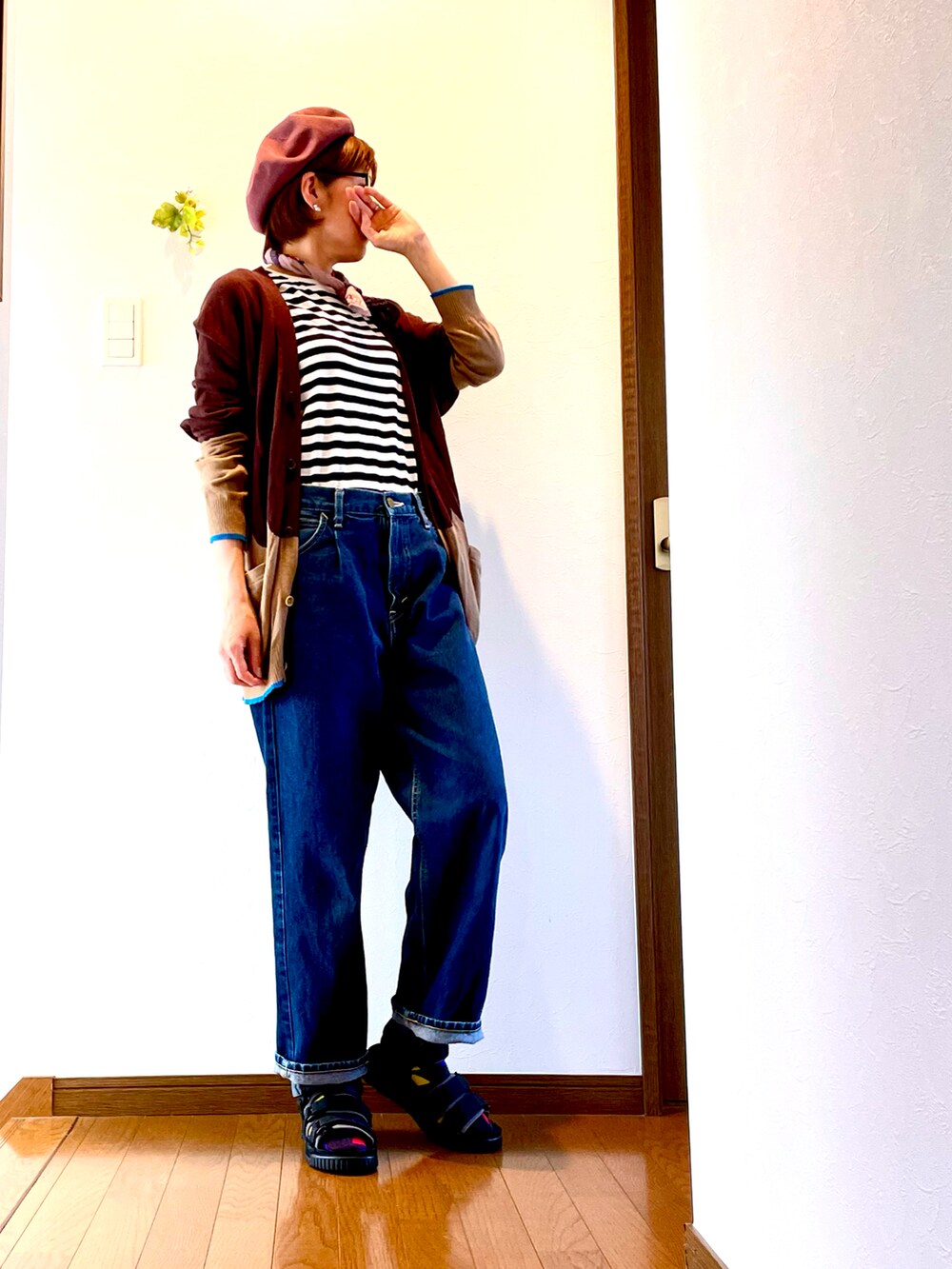 ブラウン系のカーディガン/ボレロ、ホワイト系のTシャツ/カットソー、ブルー系のデニムパンツを着用したレディースの夏コーディネートの3枚目の写真