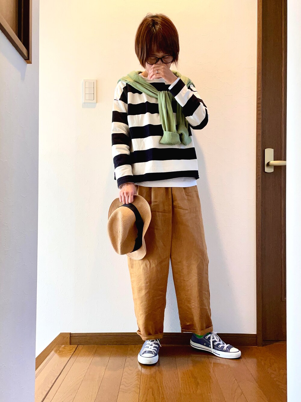 ブラック系のTシャツ/カットソー、ベージュ系のその他パンツ、ブルー系のスニーカーを着用したレディースの春コーディネートの2枚目の写真