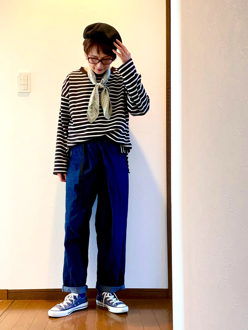 ブルー系のデニムパンツ、ブラック系のTシャツ/カットソー、ブルー系のスニーカーを着用したレディースの秋コーディネートの3枚目の写真