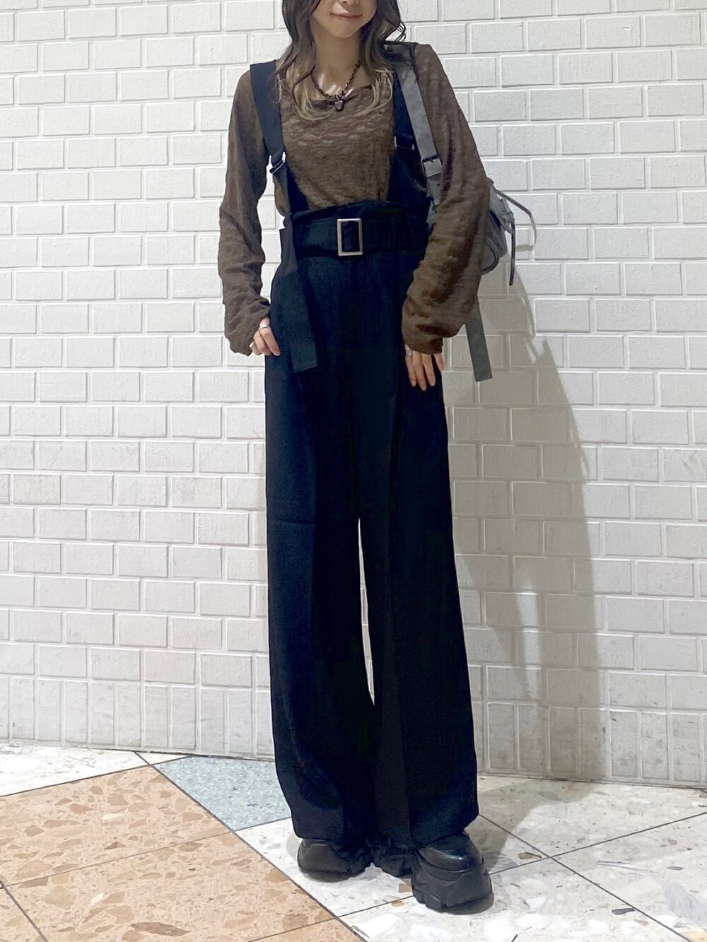 ブラック系のブーツ、ブラック系のスラックス、ブラウン系のTシャツ/カットソーを着用したレディースの秋コーディネートの6枚目の写真