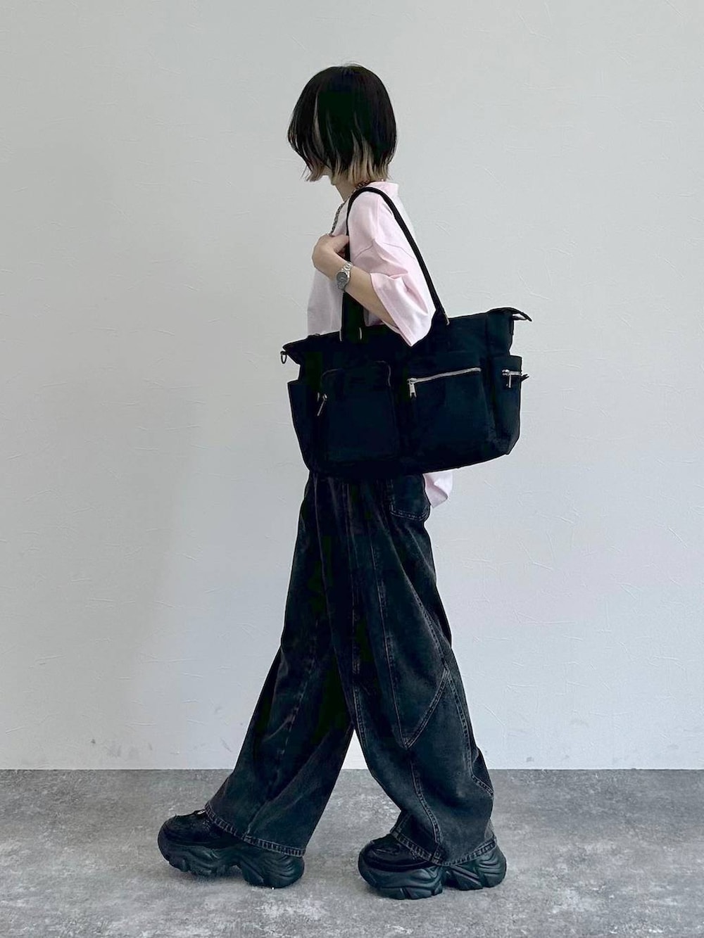 ブラック系のスニーカー、ブラック系のボストンバッグ、ブラック系のデニムパンツを着用したレディースの春コーディネートの5枚目の写真