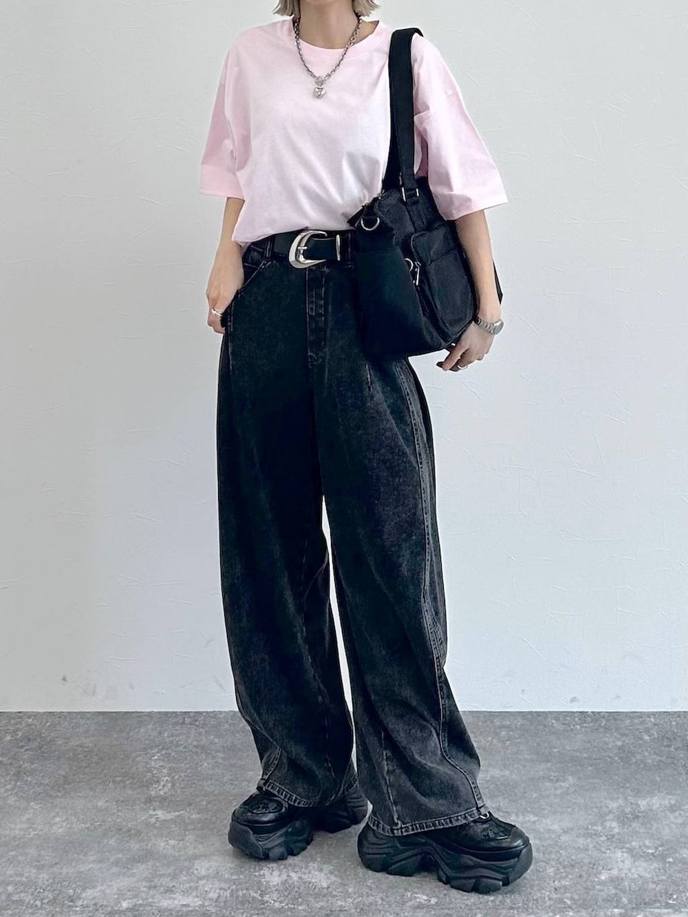 ブラック系のスニーカー、ブラック系のボストンバッグ、ブラック系のデニムパンツを着用したレディースの春コーディネートの2枚目の写真