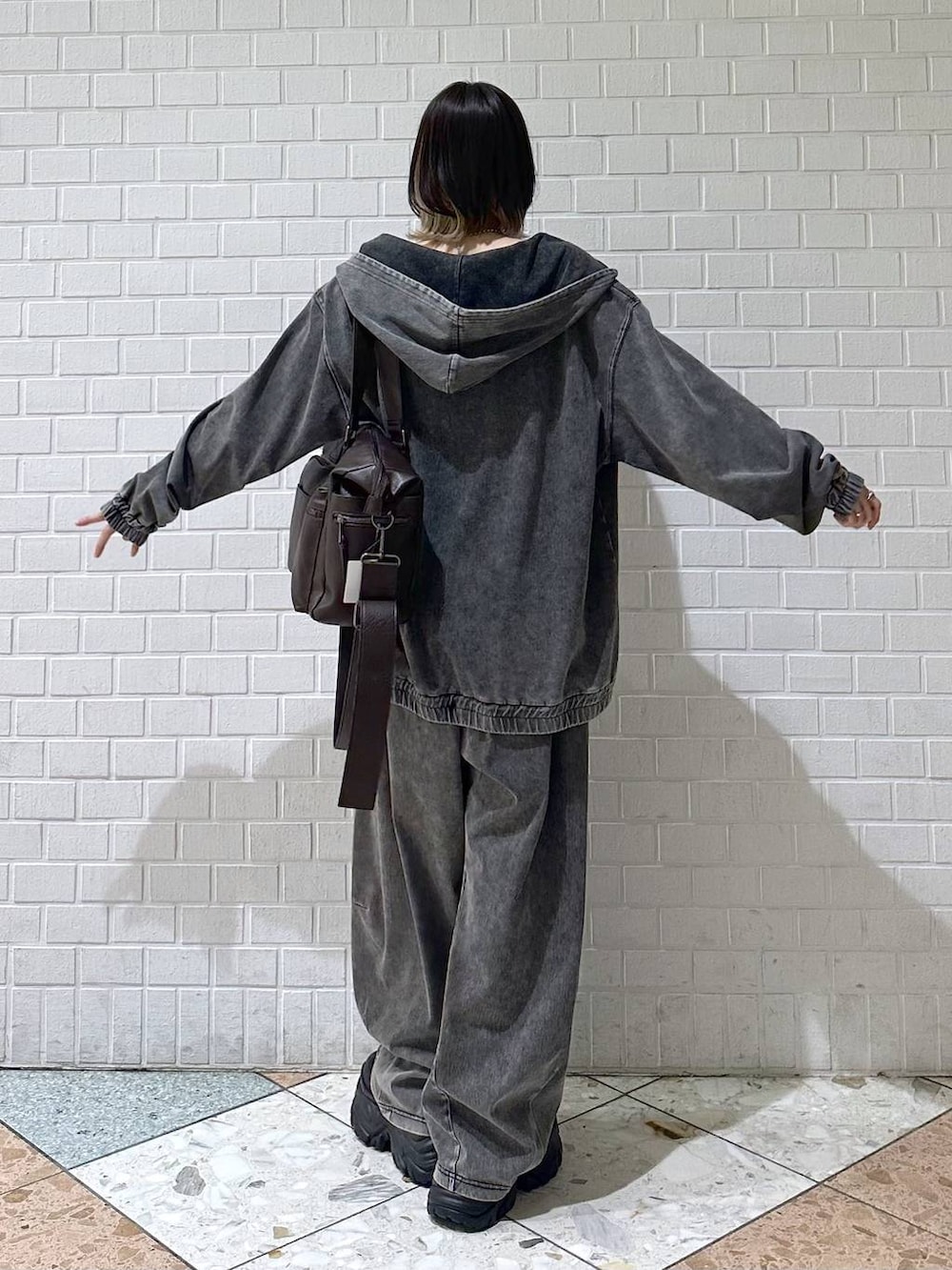 ブラック系のブーツ、ブラック系のキャミソール、ブラウン系のボストンバッグを着用したレディースの冬コーディネートの6枚目の写真