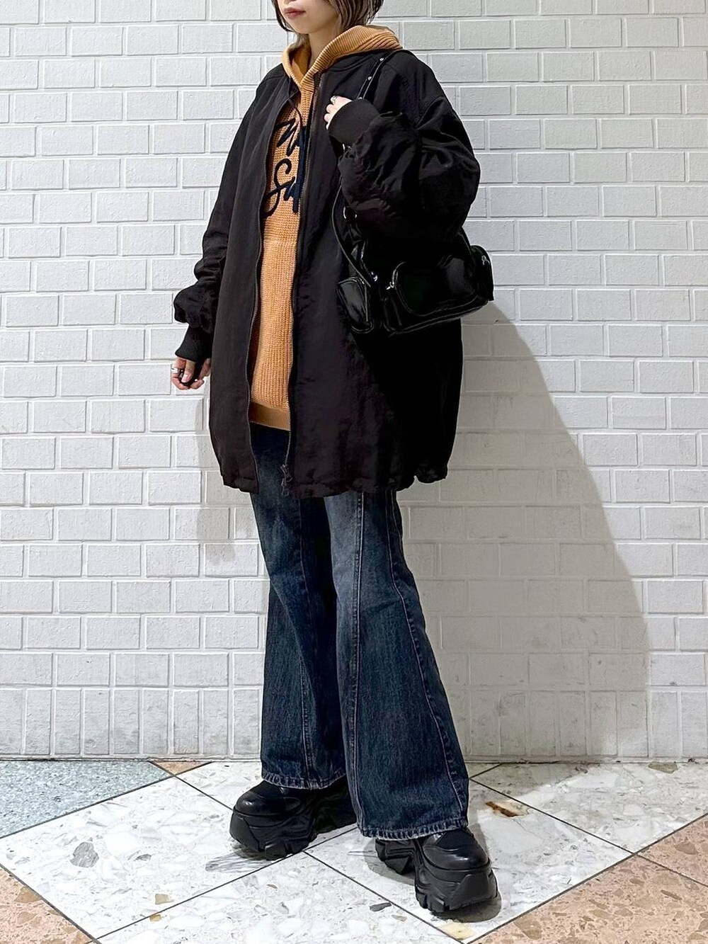 ブラック系のブーツ、ブルー系のデニムパンツ、ブラウン系のブルゾンを着用したレディースの秋コーディネートの4枚目の写真