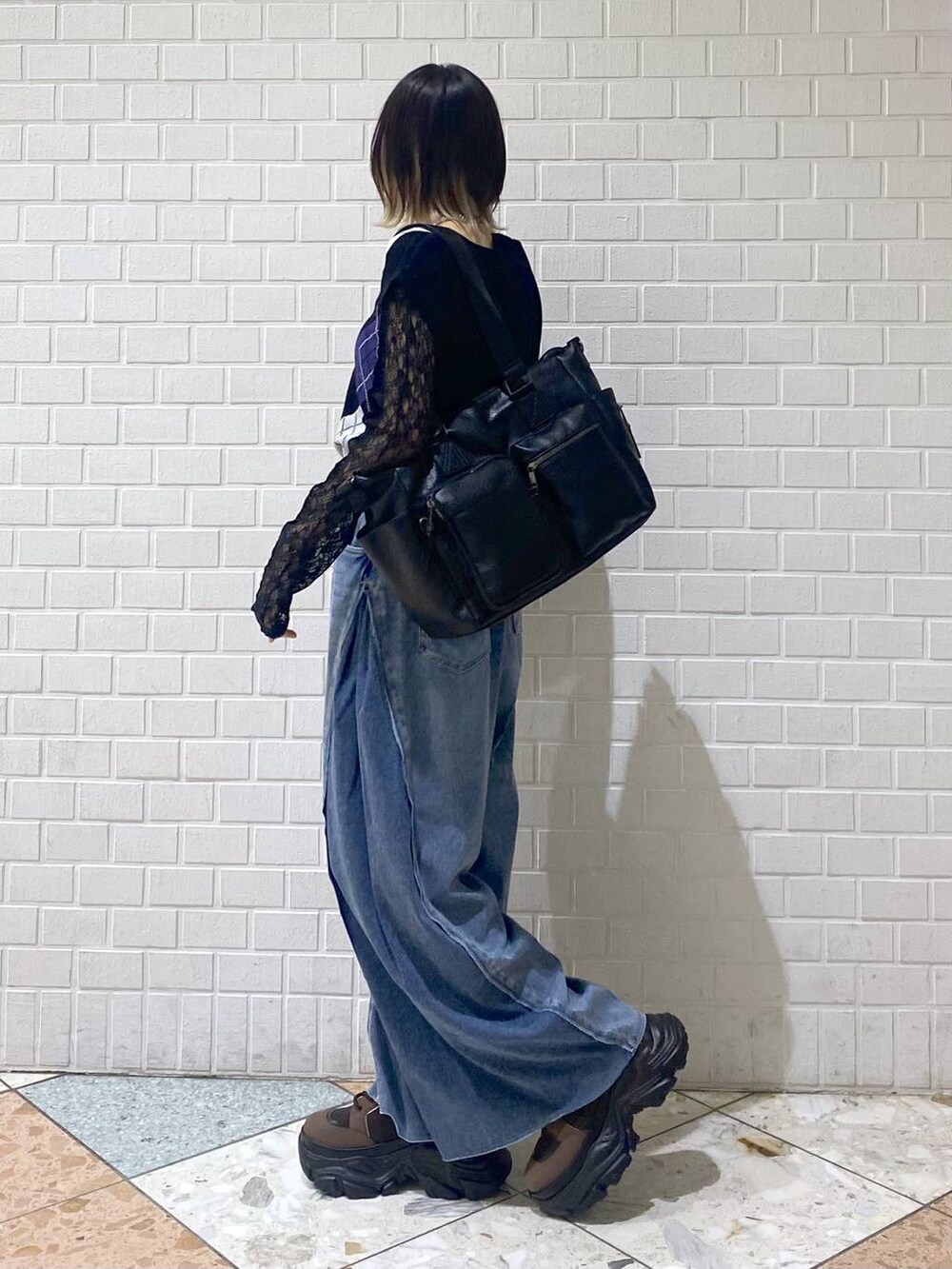 ブラウン系のブーツ、ブルー系のデニムパンツ、ブラック系のボストンバッグを着用したレディースの夏コーディネートの4枚目の写真